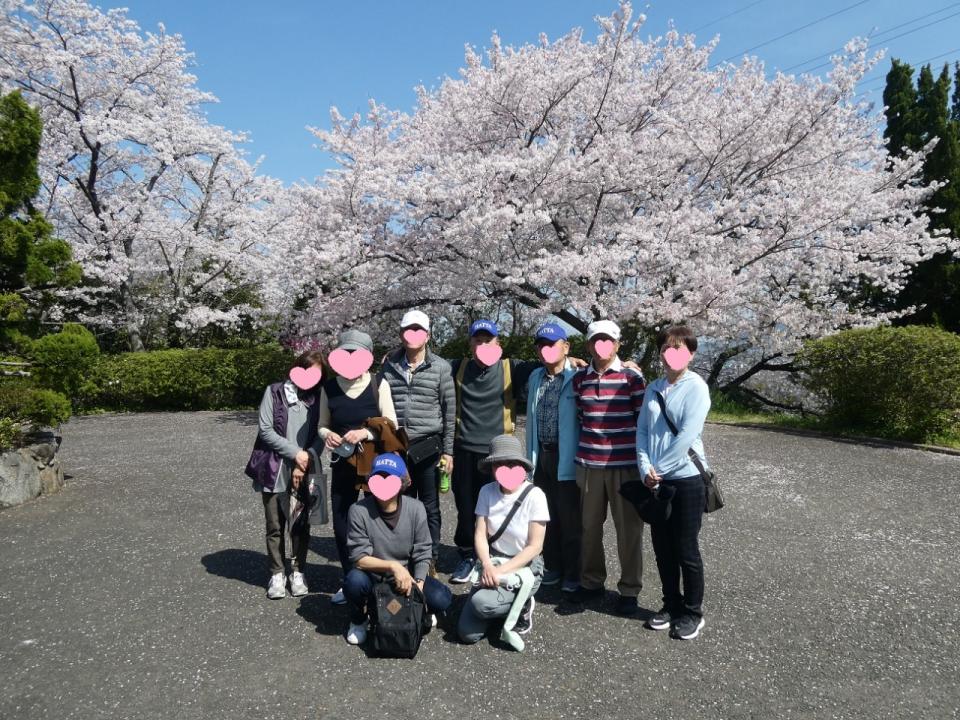 桜の木の前で10人並んでいます。